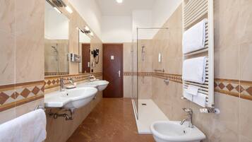 Un baño moderno con dos lavamanos, una ducha y un inodoro.