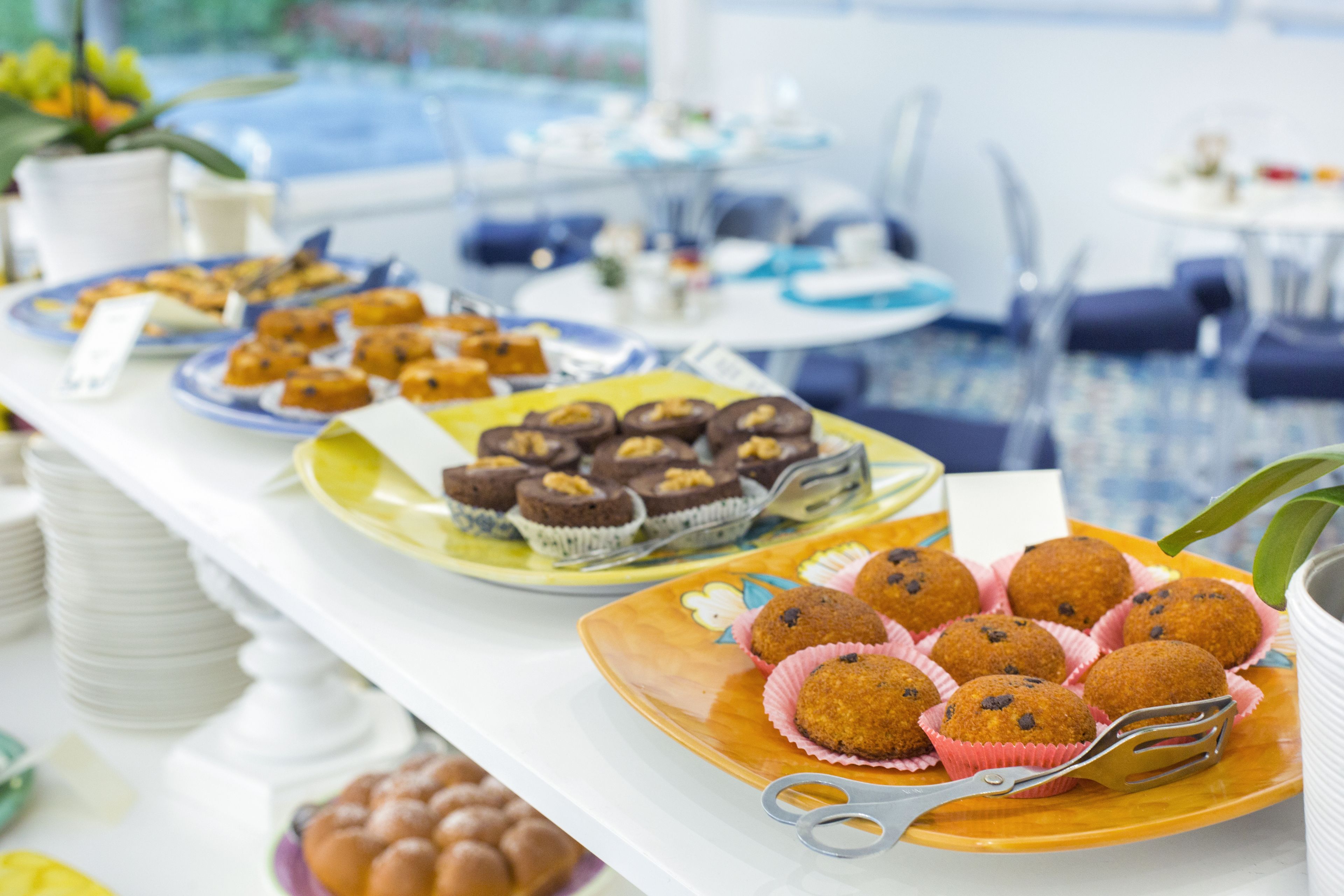 Ein Buffet mit verschiedenen Speisen, darunter Cupcakes und Muffins, in einem Hotel.
