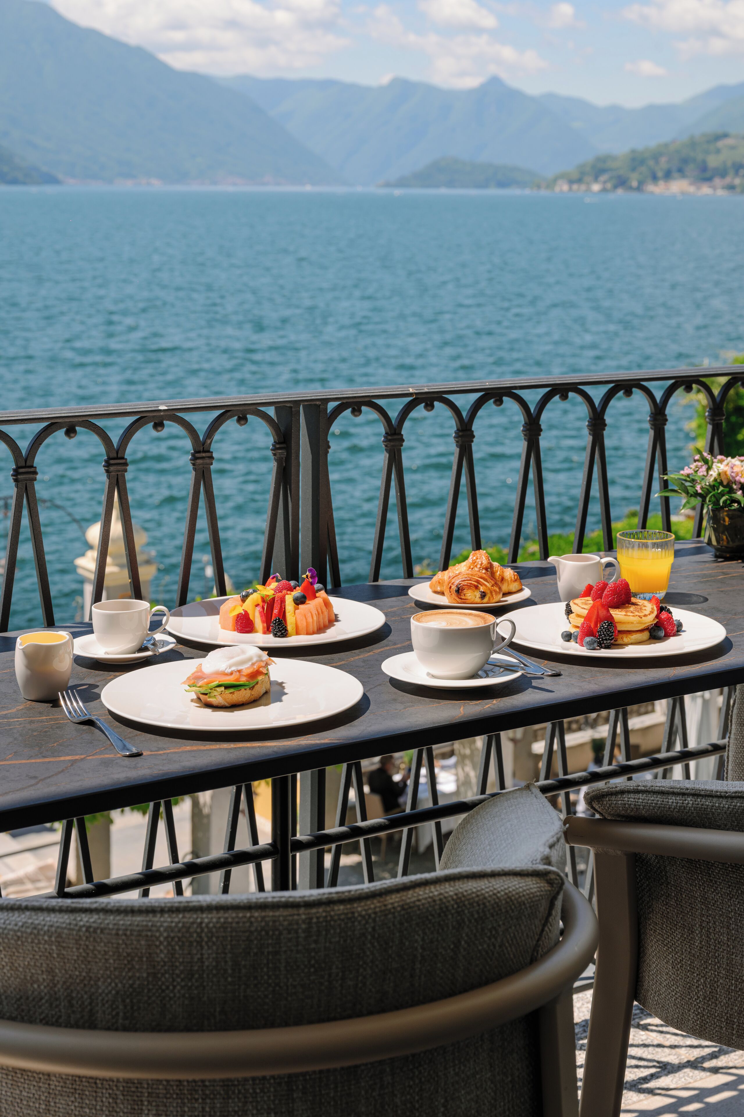 A table set with breakfast items and a view of a lake.