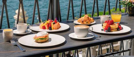 A table set with breakfast items and a view of a lake.