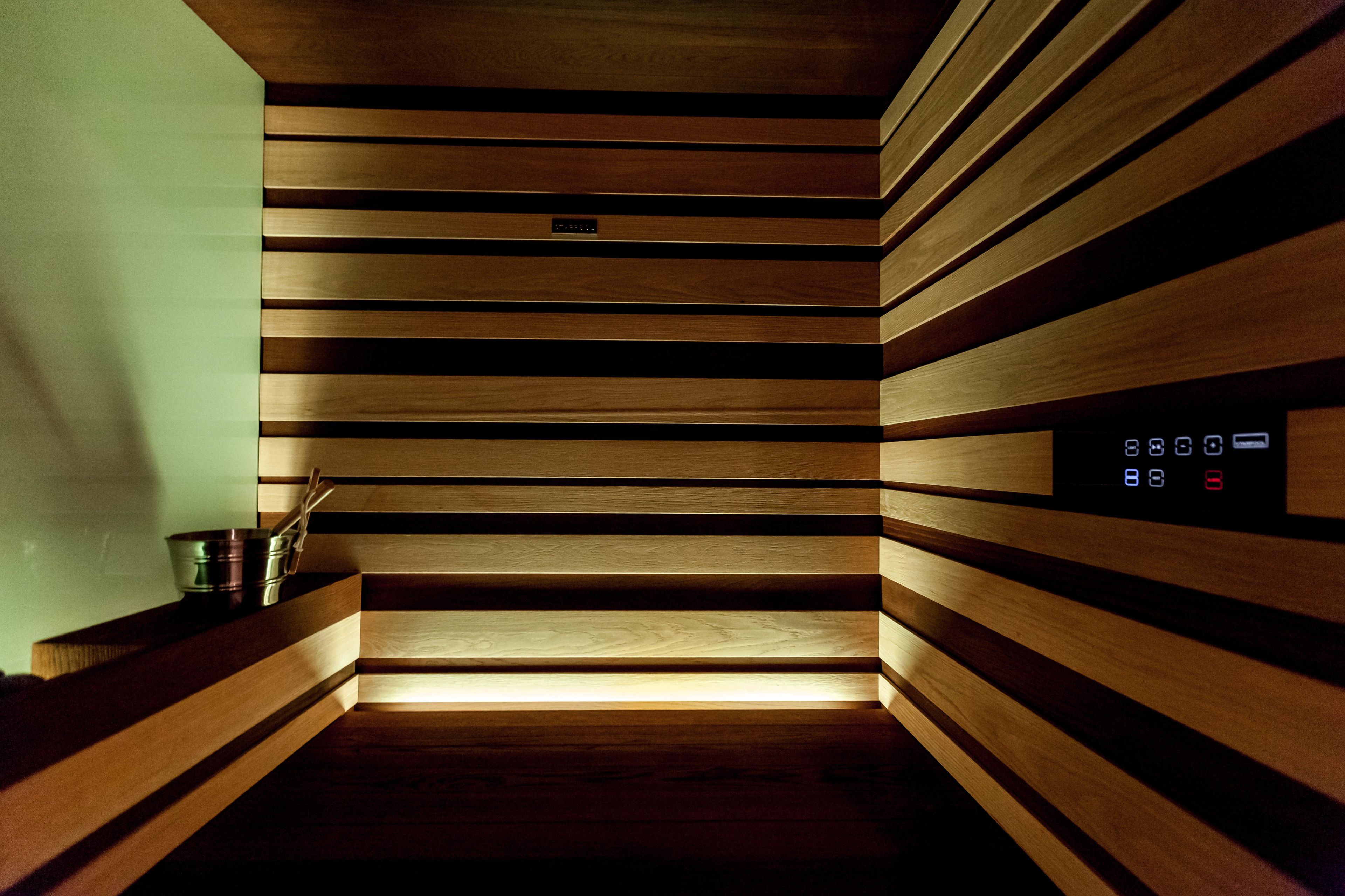 Un intérieur en bois, doté d’un panneau de commande et d’un petit récipient en métal posé sur une étagère.