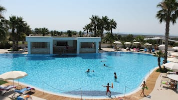 Piscine extérieure en saison, parasols, chaises longues