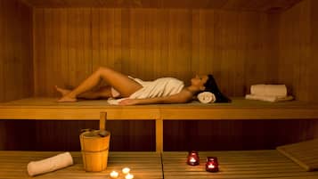 Relax in a serene sauna with a bench for lounging, candles for ambiance, and amenities for a rejuvenating experience.