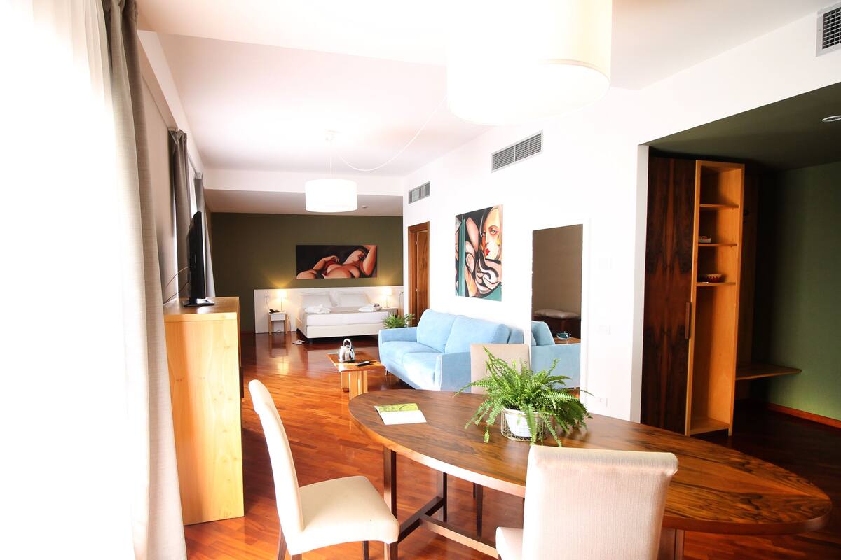 Una sala de estar moderna con comedor, un sofá, una mesa de centro y un televisor.