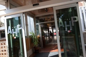 Entrada de un hotel con puertas de vidrio y un letrero que dice "AHP".