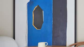Una mesa redonda de madera con una taza blanca y un periódico.
