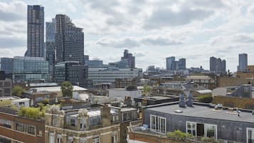 A cityscape with modern and historic buildings, including a prominent skyscraper and a mix of residential and commercial structures.