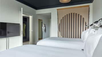 A hotel room with a bed, a TV, a wardrobe, and a unique wall decoration.