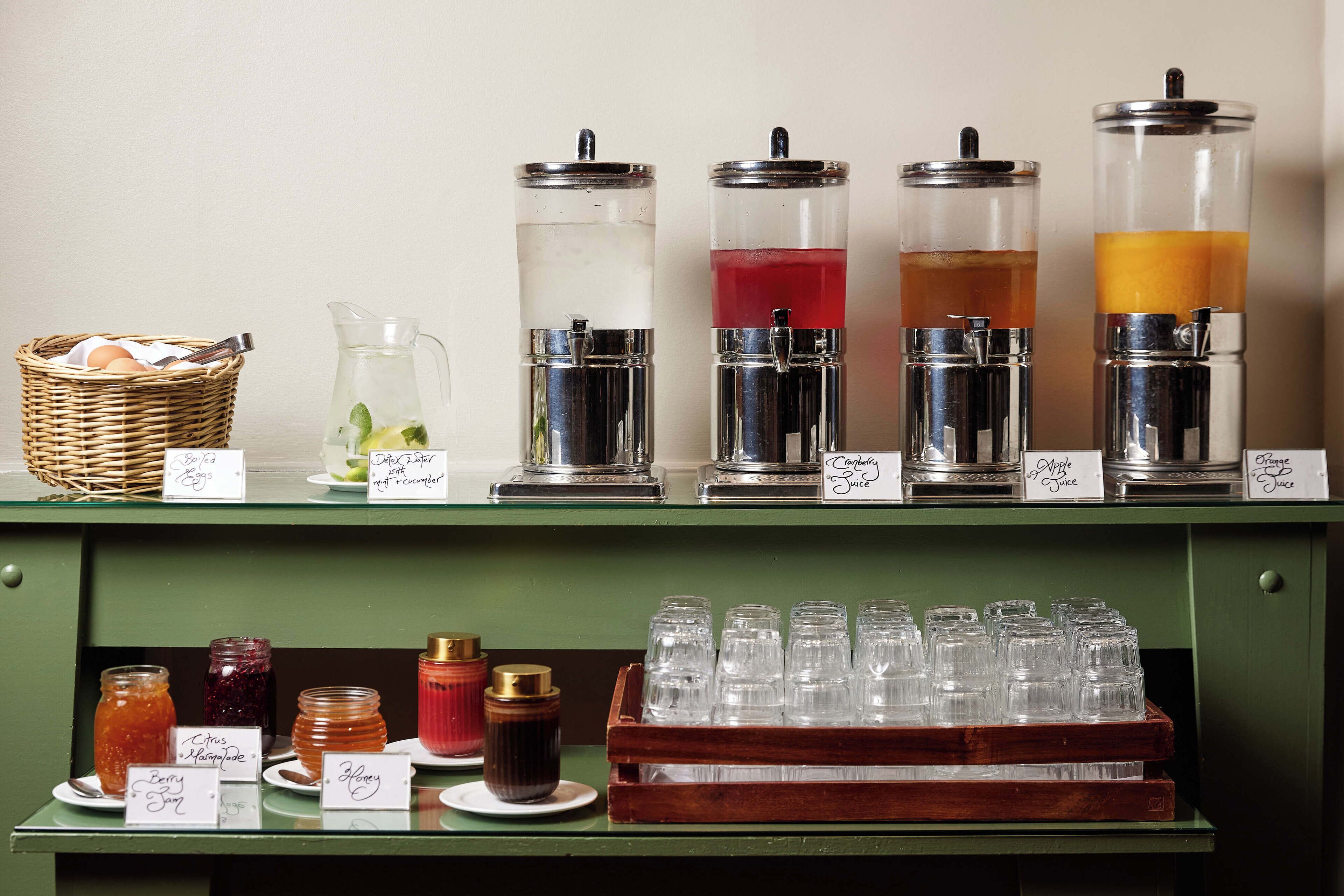 A beverage station with various drink dispensers and containers.