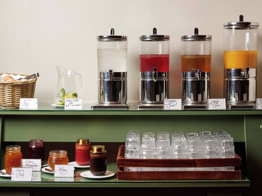 A beverage station with various drink dispensers and containers.