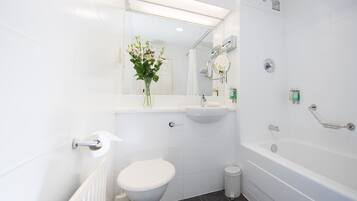 Une salle de bain moderne équipée de toilettes, d’un lavabo et d’une baignoire.