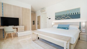 Une chambre d’hôtel moderne équipée d’un lit, d’un bureau, d’une télévision et d’une armoire.