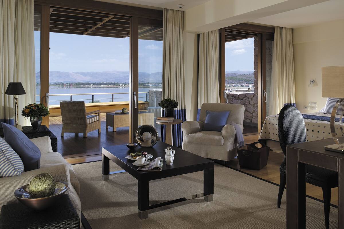 Amplia sala de estar con un gran ventanal con vistas panorámicas, un área de estar acogedora y una mesa de comedor con un tazón de comida.