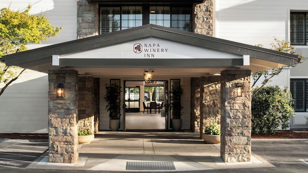 Ingången till Napa Winery Inn pryds av stenkantade pelare, en täckt uteplats och en skylt ovanför ingången.