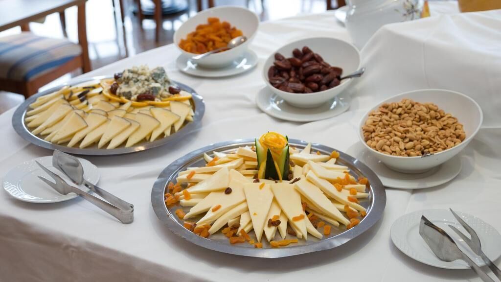 Un tavolo con buffet assortito, con formaggi, frutta e noci.