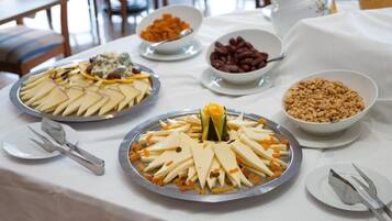 Un tavolo con buffet assortito, con formaggi, frutta e noci.