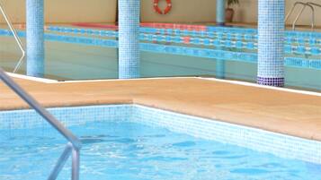 Una piscina con bordes de azulejos y un flotador en la pared.