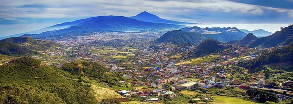 A town nestled in a valley with a prominent mountain in the background.