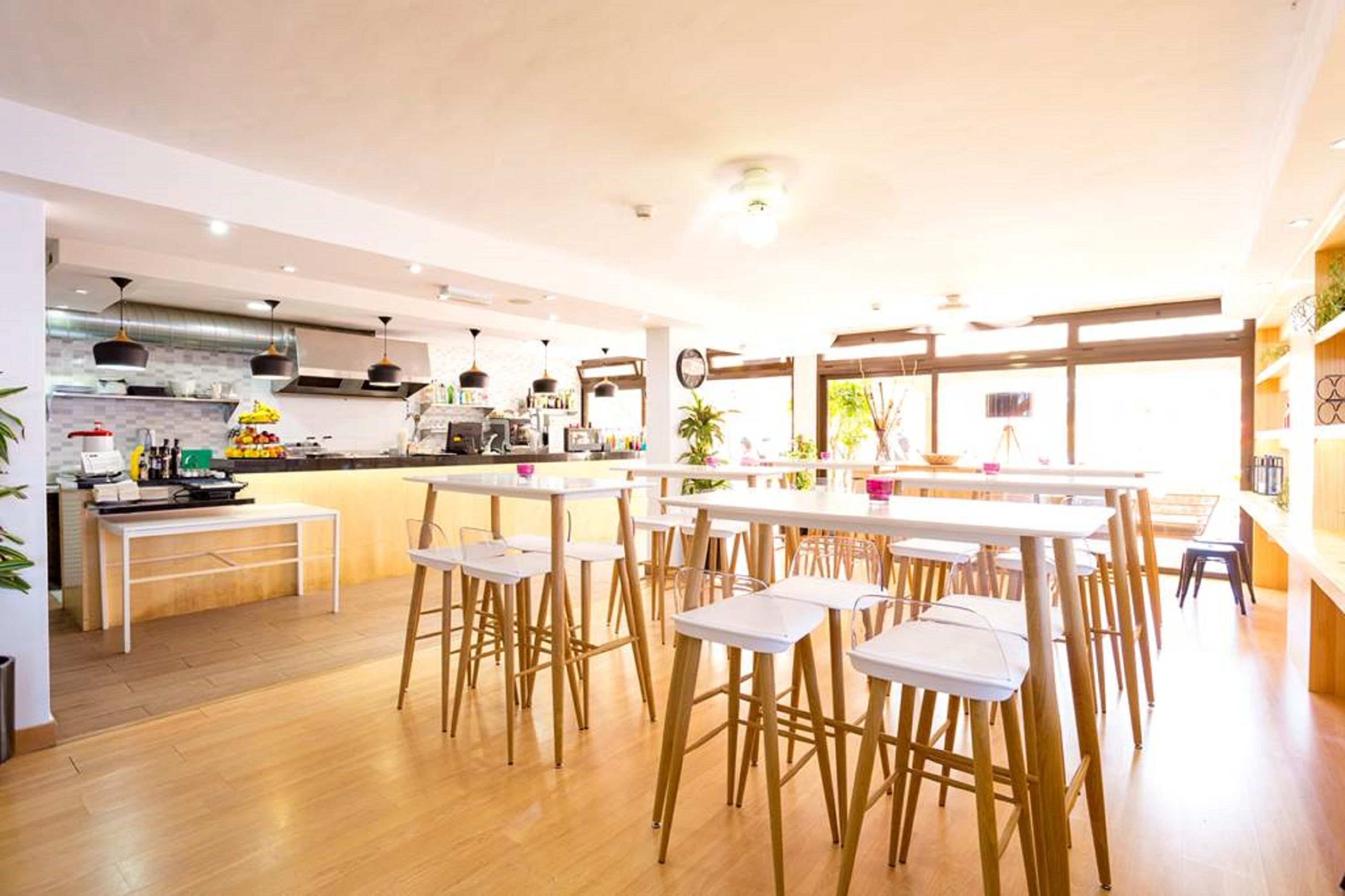 Una cocina moderna con barra, piso de madera y ventanas amplias.