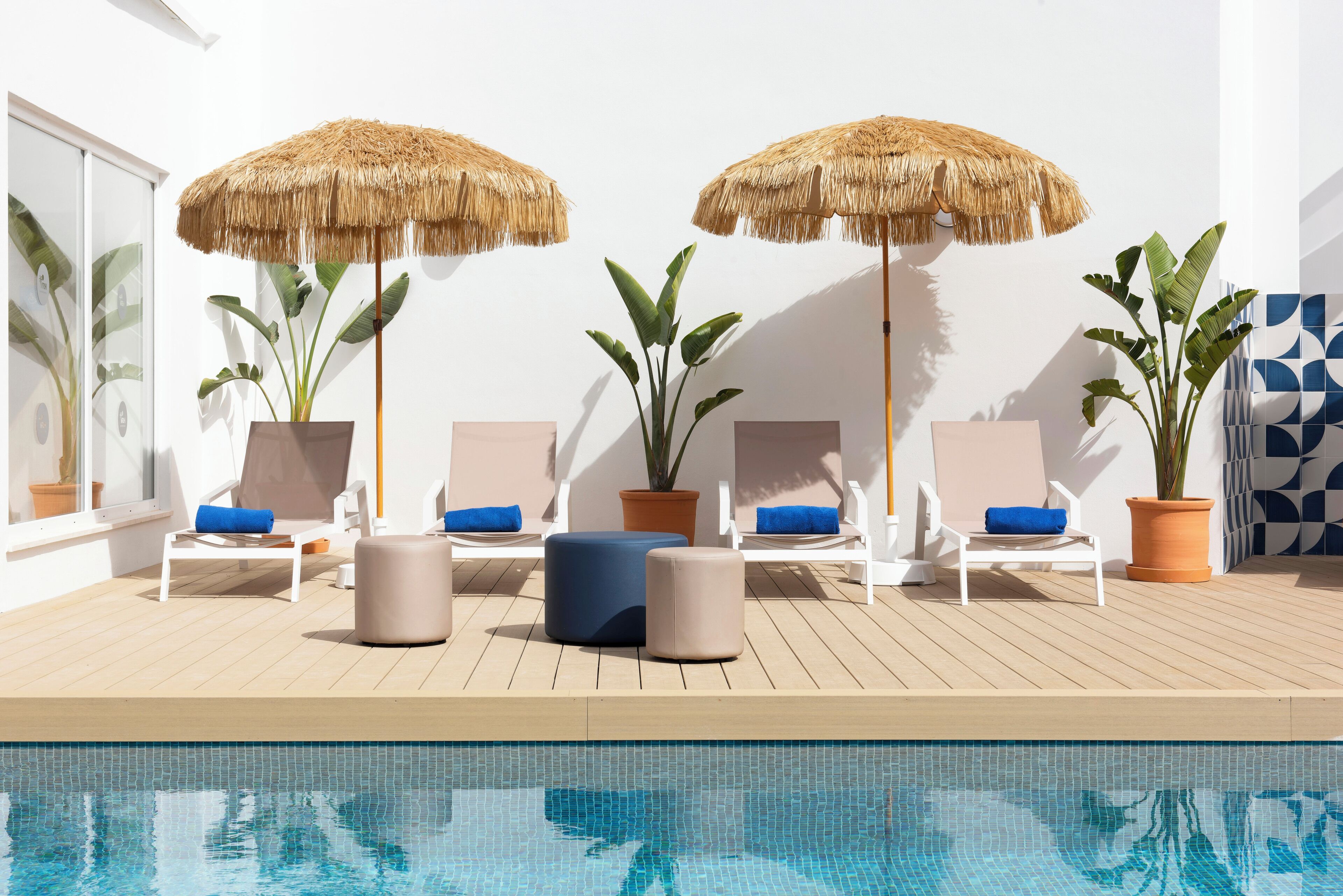 Una piscina al aire libre de temporada, sombrillas