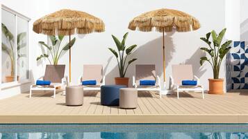 Una piscina al aire libre de temporada, sombrillas