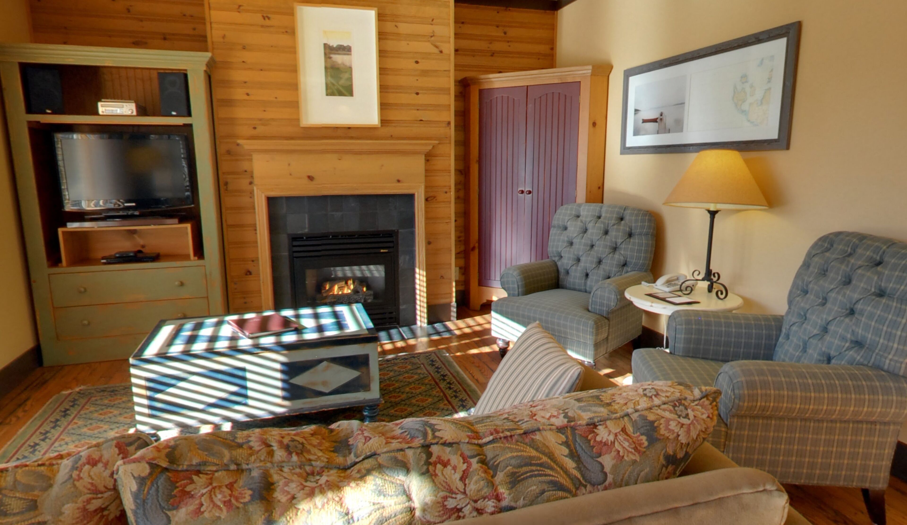 A cozy living room with a fireplace, a television, and comfortable seating.