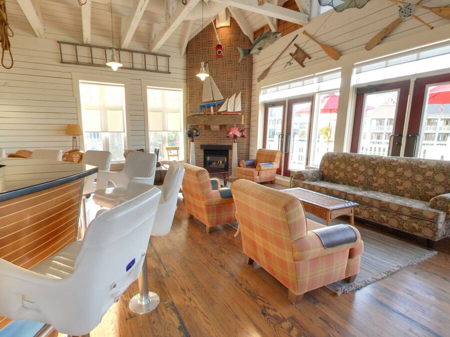 A spacious living area with a fireplace, wooden floors, and a large window.