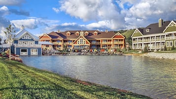 Een groot resort met meerdere gebouwen, een meer en een verzorgd gazon.
