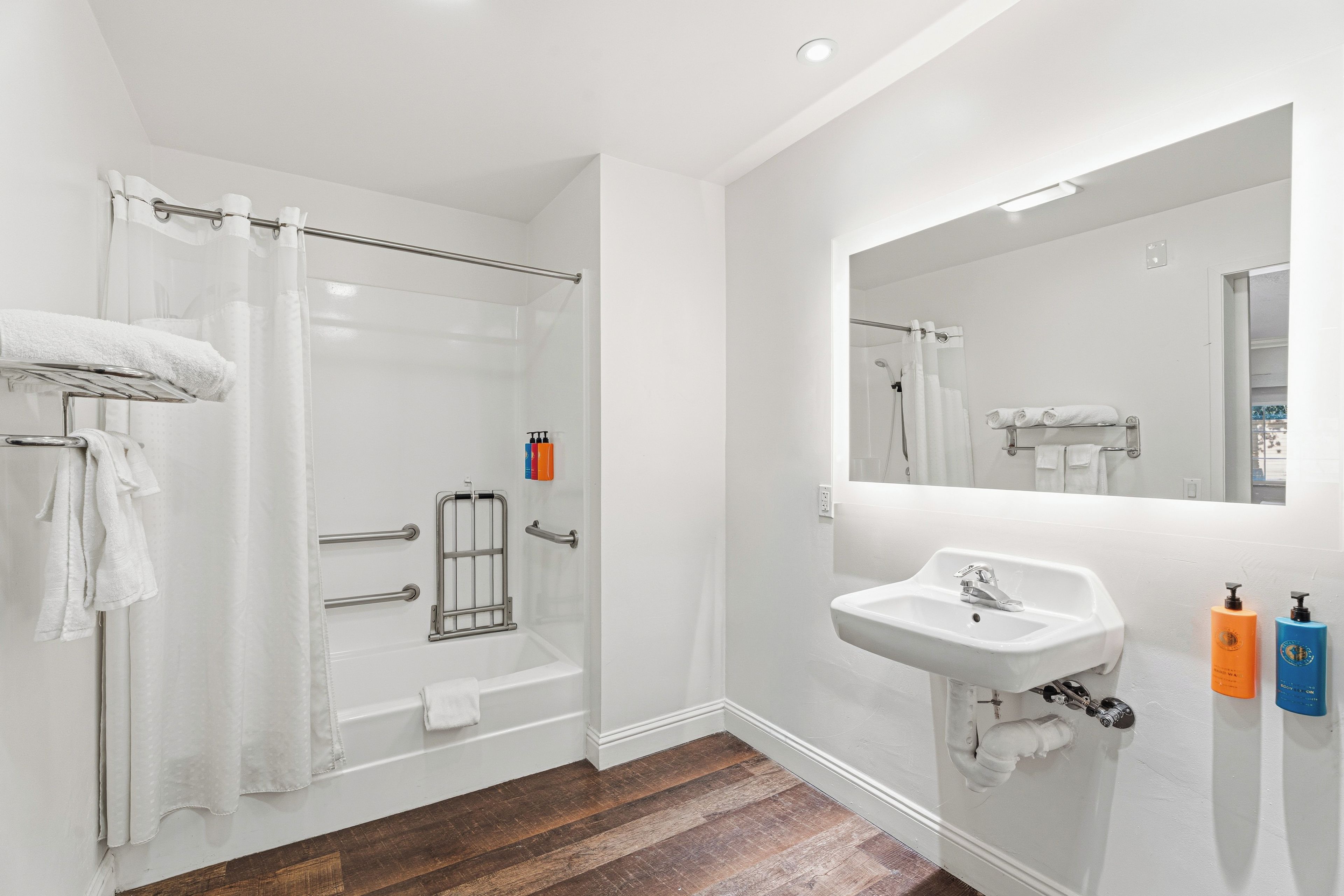 A modern bathroom with a walk-in shower, a white sink, and a large mirror.