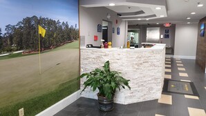 A reception area with a golf course view, a reception desk, and a potted plant. - Microtel Inn & Suites by Wyndham Augusta/Riverwatch (Augusta)