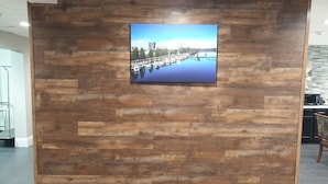 A wall with a large picture of a waterfront scene. - Microtel Inn & Suites by Wyndham Augusta/Riverwatch (Augusta)