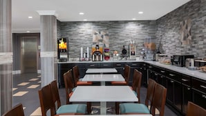 A modern kitchen with a central island, dark cabinetry, and a patterned backsplash. - Microtel Inn & Suites by Wyndham Augusta/Riverwatch (Augusta)