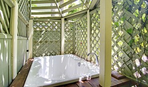 A wooden deck with a white hot tub. - Inn at Depot Hill (Capitola)