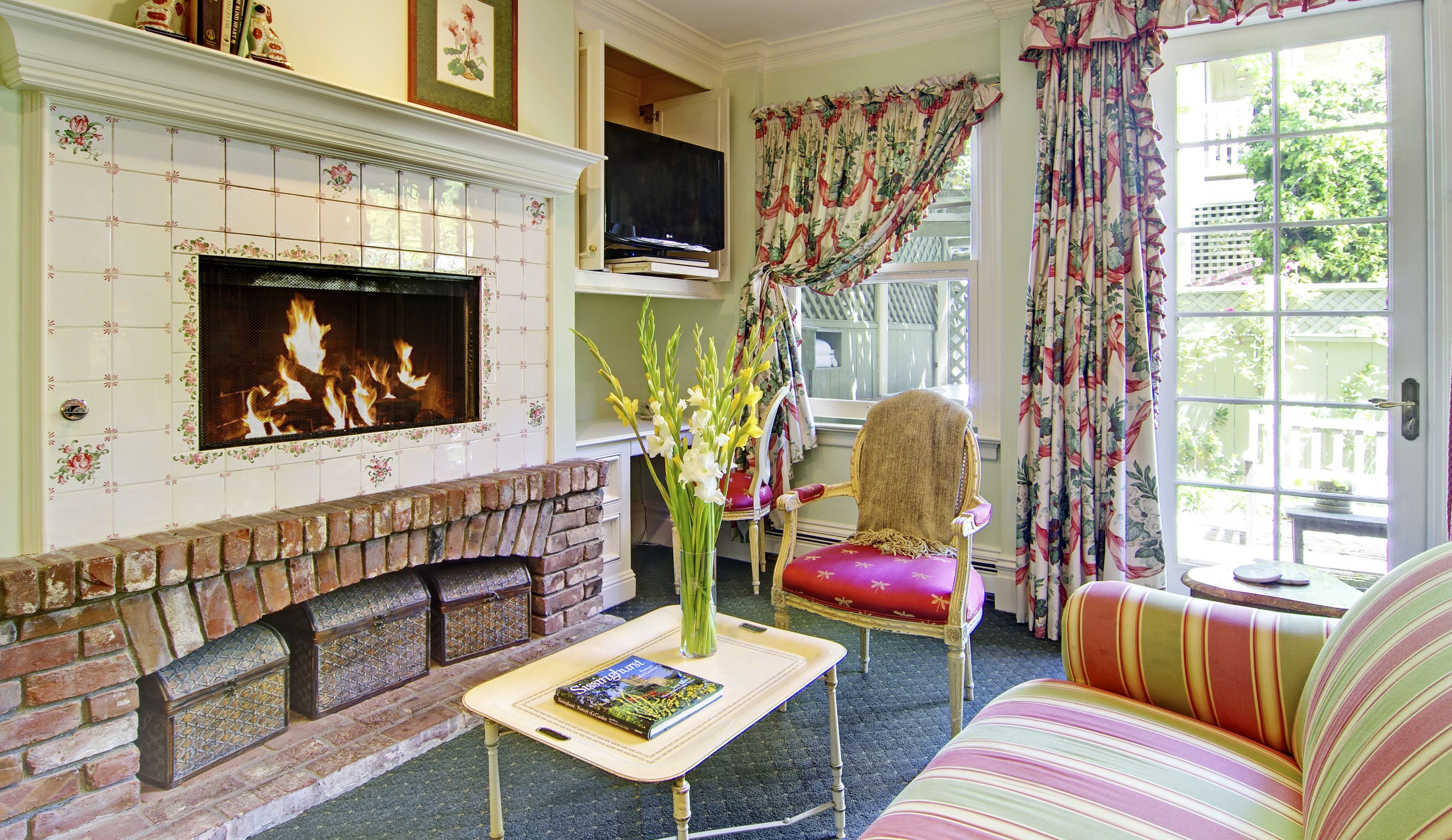 A living room with a fireplace, a television, a sofa, and a chair.