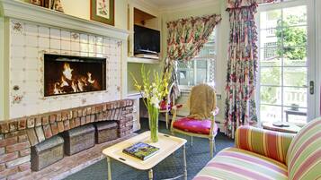 A living room with a fireplace, a television, a sofa, and a chair.