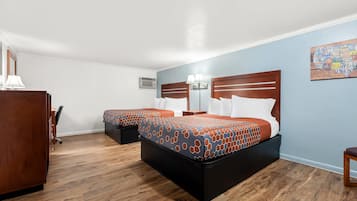 Ein Hotelzimmer mit zwei Betten, einem Schreibtisch und einem Stuhl.