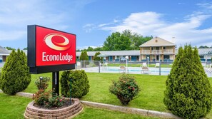 Un hotel llamado EconoLodge con piscina, un patio cercado y un edificio con balcón.