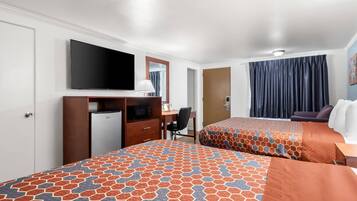 A hotel room with two beds, a desk, a television, and a wardrobe.