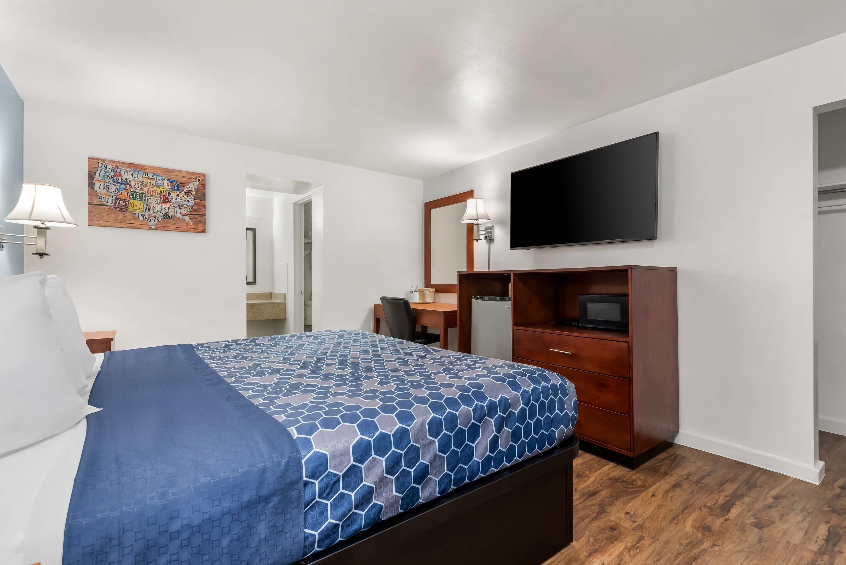 Une chambre d’hôtel équipée d’un lit, d’une télévision, d’un bureau et d’une armoire.