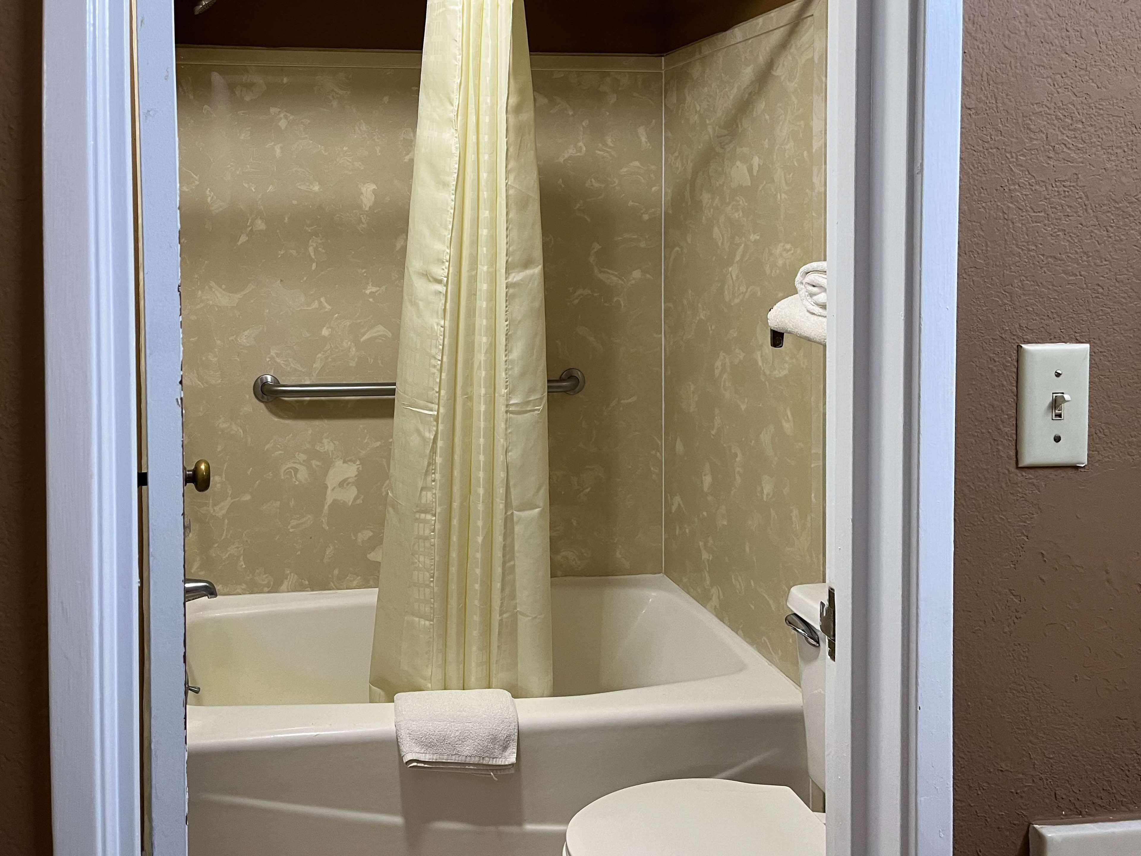 Un baño con bañera, inodoro y cortina de ducha.