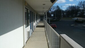 A covered walkway with a view of a parking lot and a road. - Motel 6 Millington, TN (Millington)