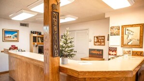A reception desk with a 'WELCOME' sign, a small potted plant, framed pictures on the wall, and a 'WILDCAT INN' sign.
