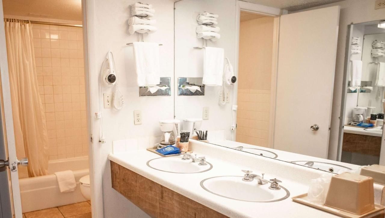 Ein Badezimmer mit zwei Waschbecken, einer Dusche und einem großen Spiegel.