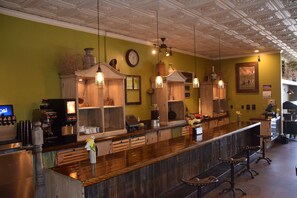 A bar area with a wooden counter, hanging lights, and a clock on the wall. - National 9 Gillette (Gillette)