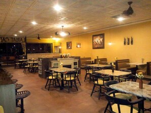 A restaurant with multiple tables and chairs, a bar area, and a counter. - National 9 Gillette (Gillette)