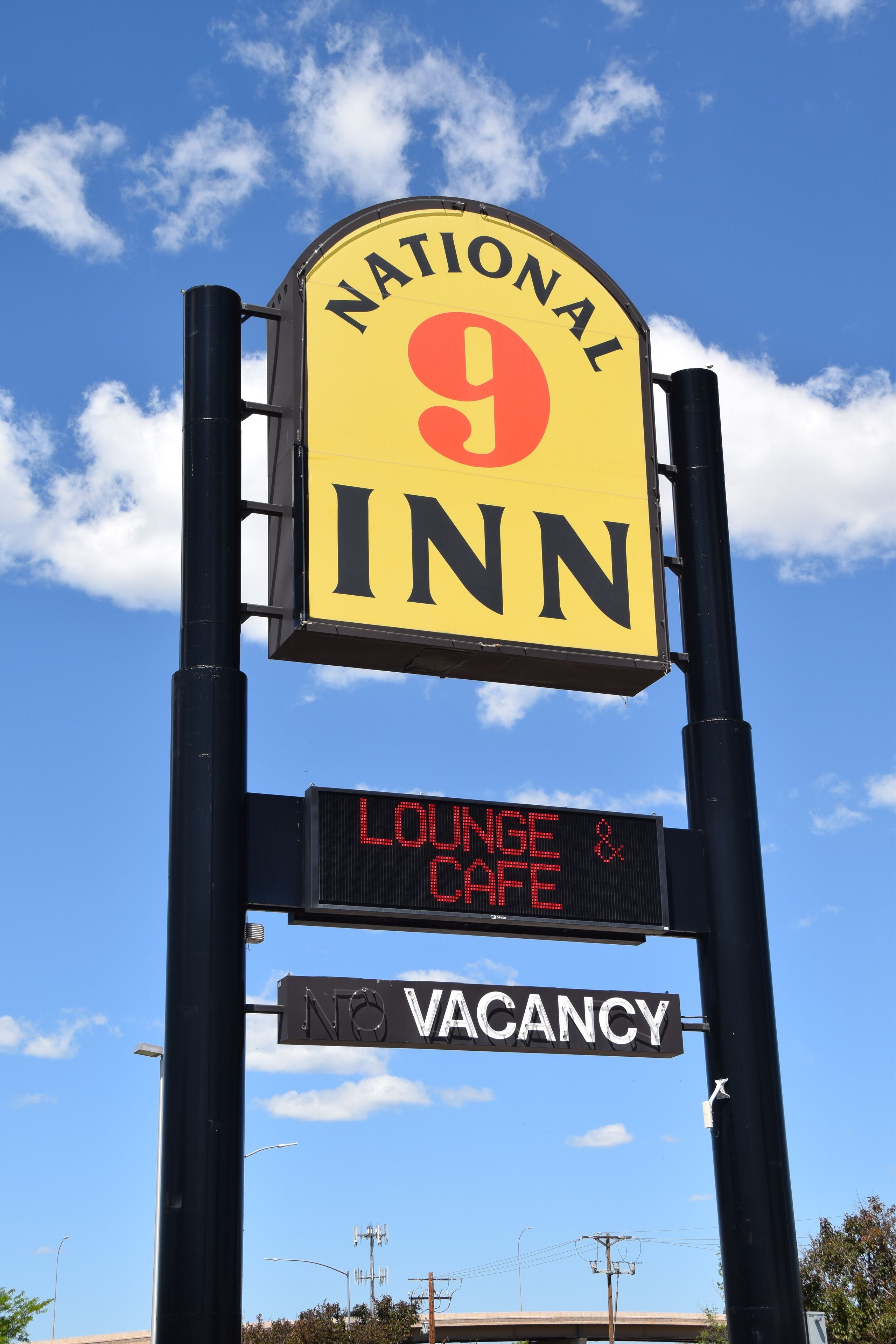 A sign for National 9 Inn with a digital display indicating no vacancies and a lounge & cafe.