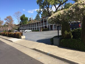Un bâtiment avec un parking et un trottoir.