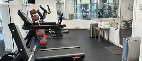 A gym with treadmills, weight machines, and exercise balls.
