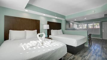 Une chambre d’hôtel avec deux lits, une petite table, une chaise et une fenêtre avec des stores.
