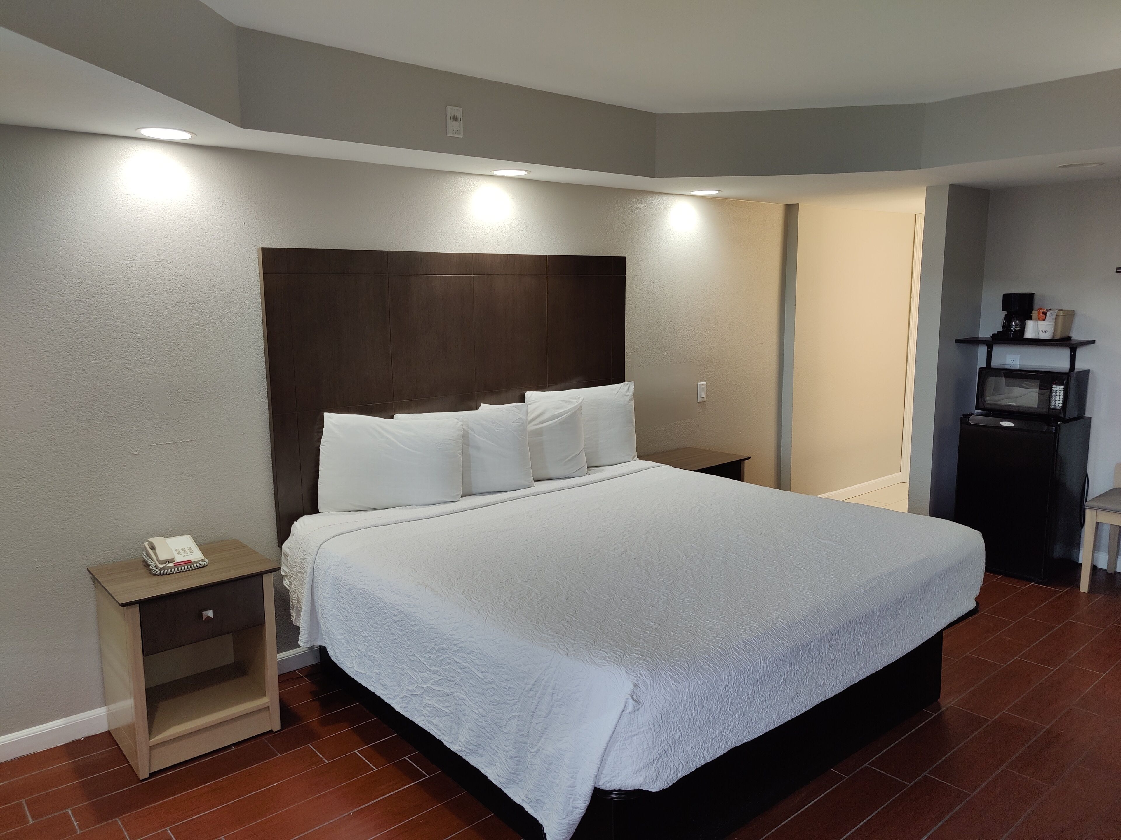 Una cama bien hecha con sábanas blancas en una habitación de hotel.